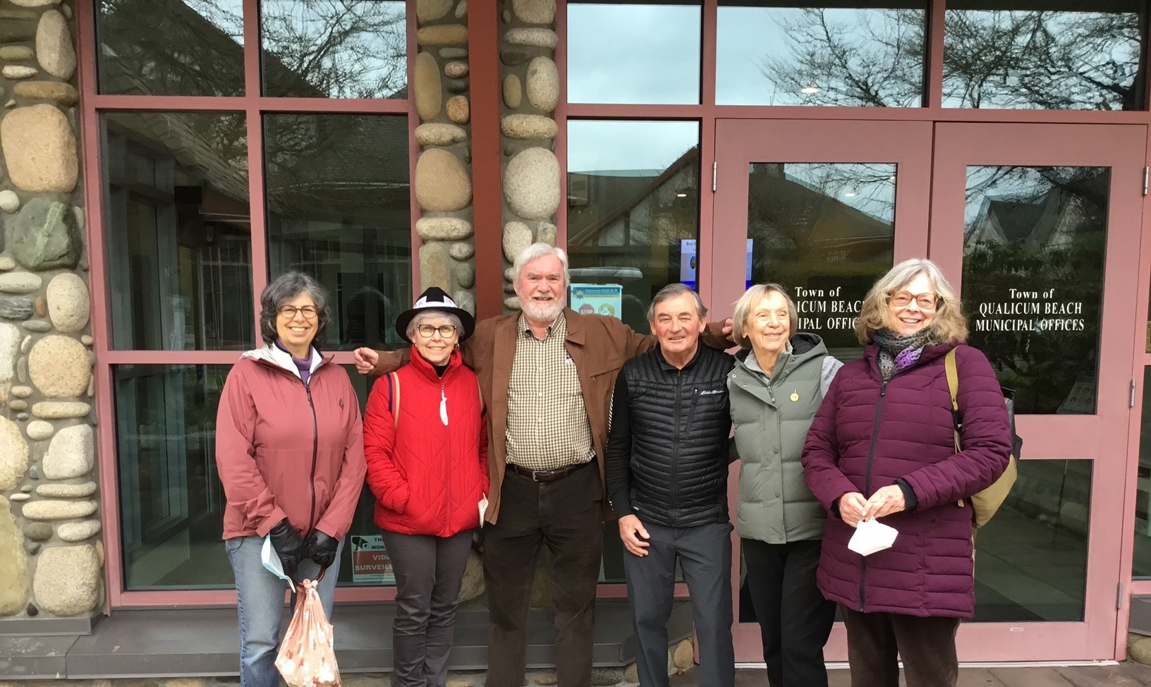 A small group of people standing outside Qualicum Beach municipal offices