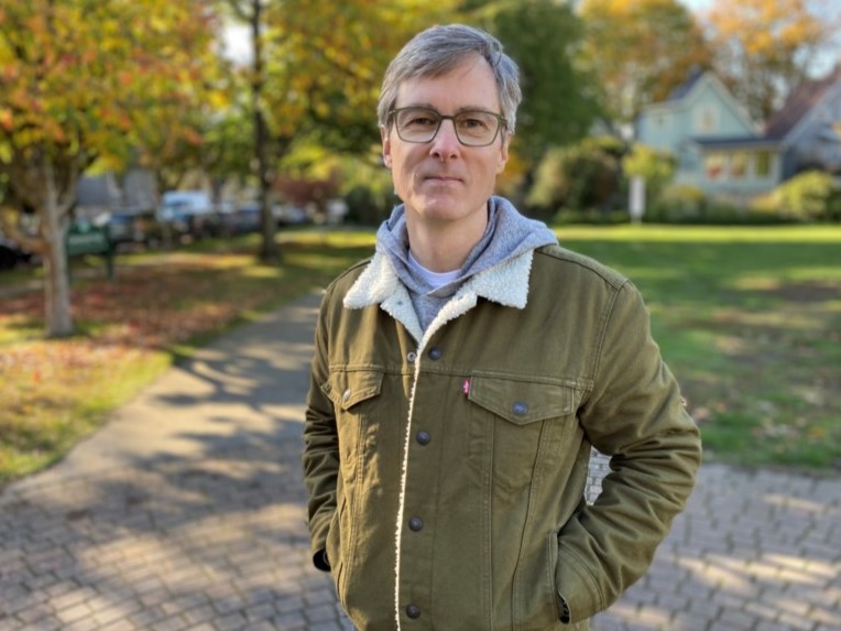 Law Prof. Stepan Wood standing in a park with hands in jacket pockets.